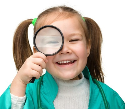 Child as a doctor with a magnifying glass