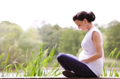 Beautiful pregnant woman by the lake