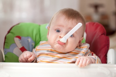 طفل مع ملعقة في الفم