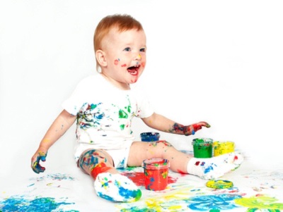 Et barn på 1,5 år leger med maling
