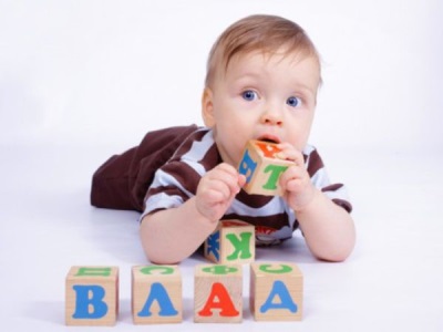 En 6 måneder gammel baby trækker et legetøj i munden