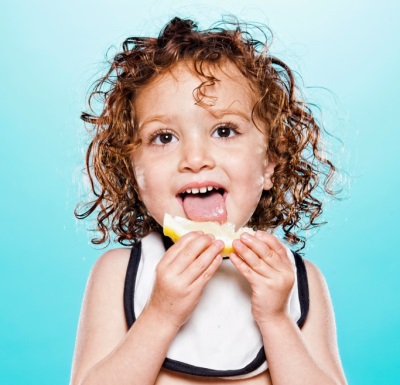 Barnet äter citron med nöje