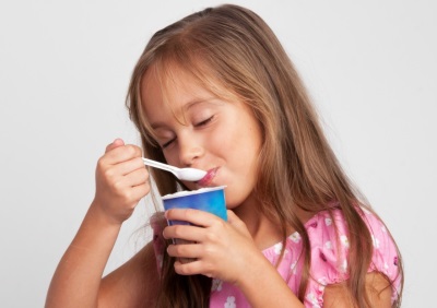 Flicka äter yoghurt