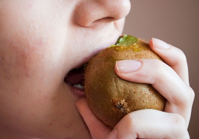 Baby eating kiwi